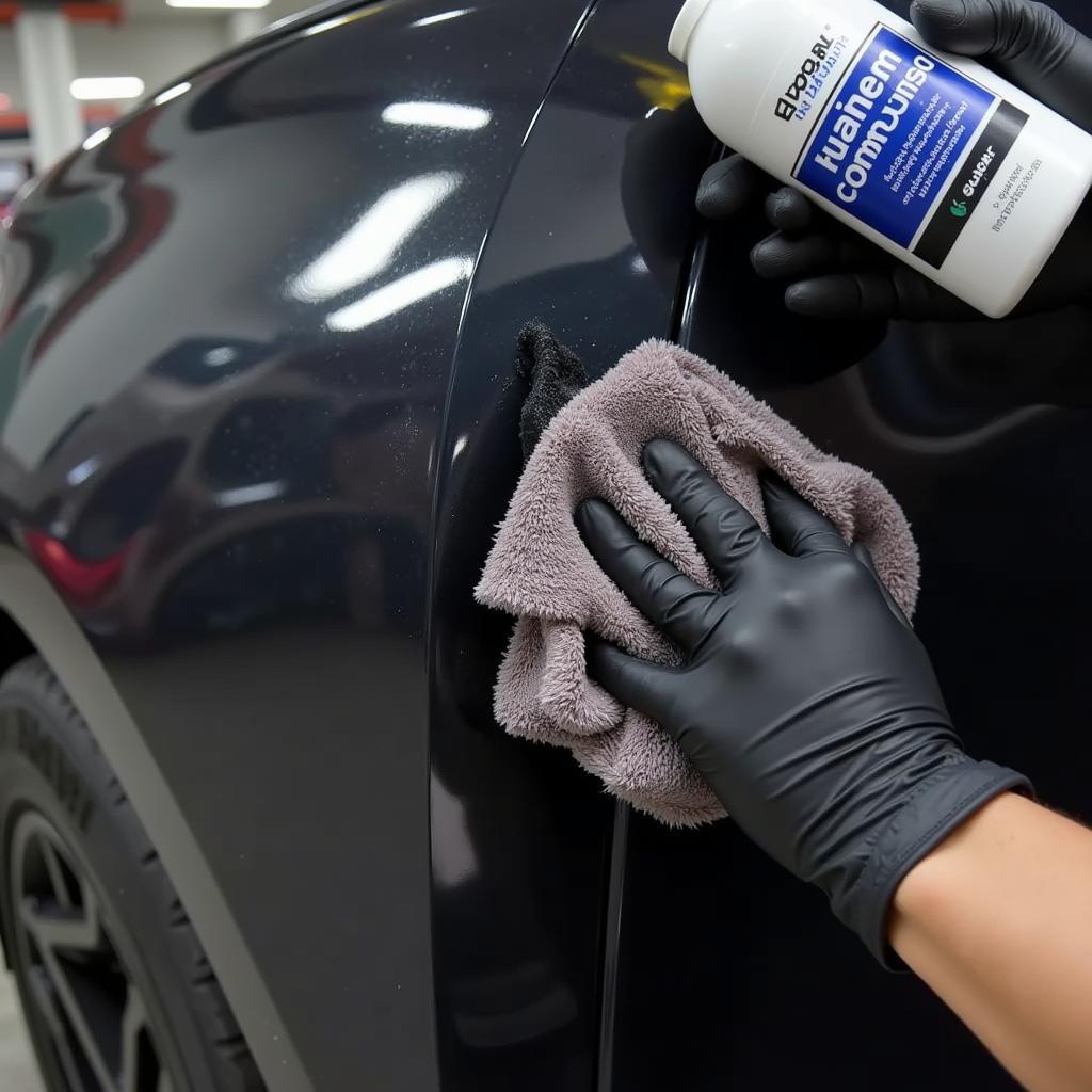 applying rubbing compound to car scratch