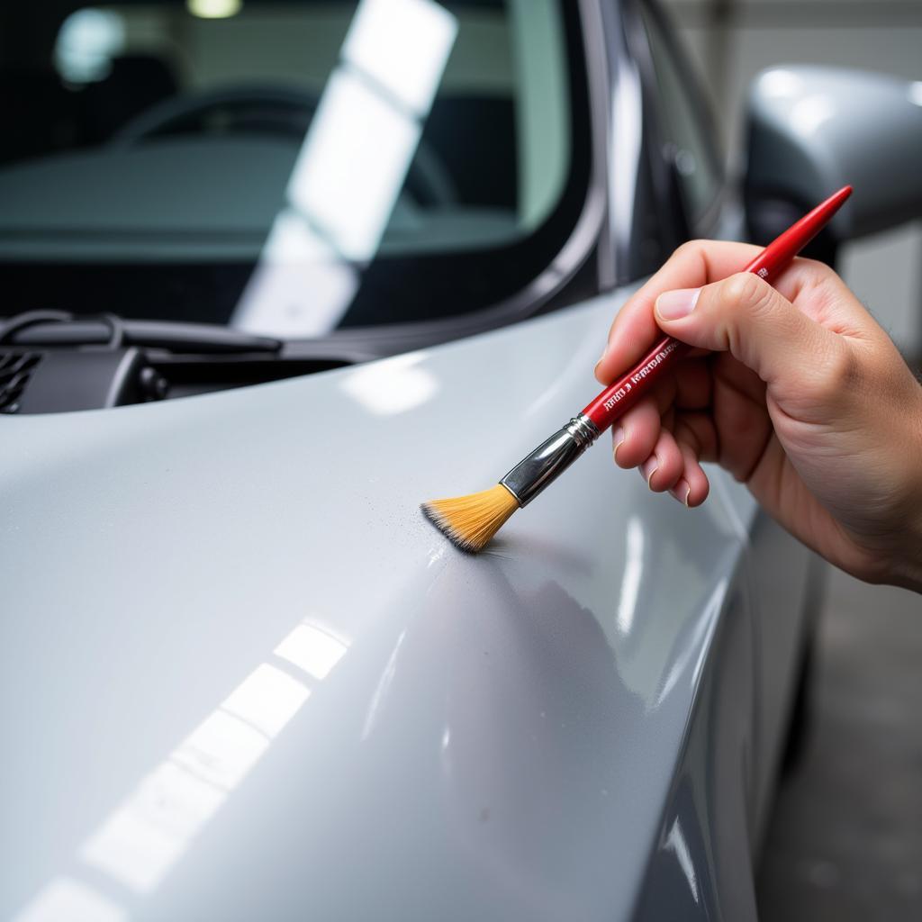 Applying touch-up paint to a rock chip on a car