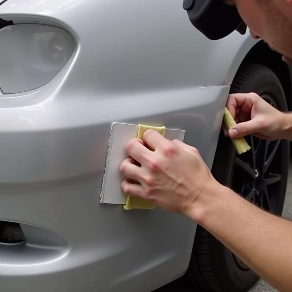 Sanding a repaired car bumper