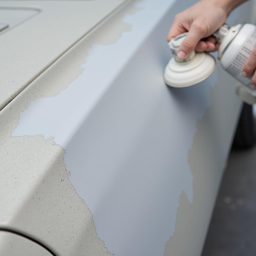 Applying primer to the sanded area before painting.