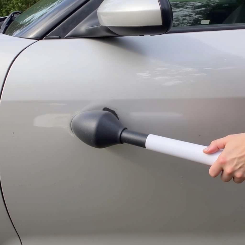 Using a plunger to remove a small car dent