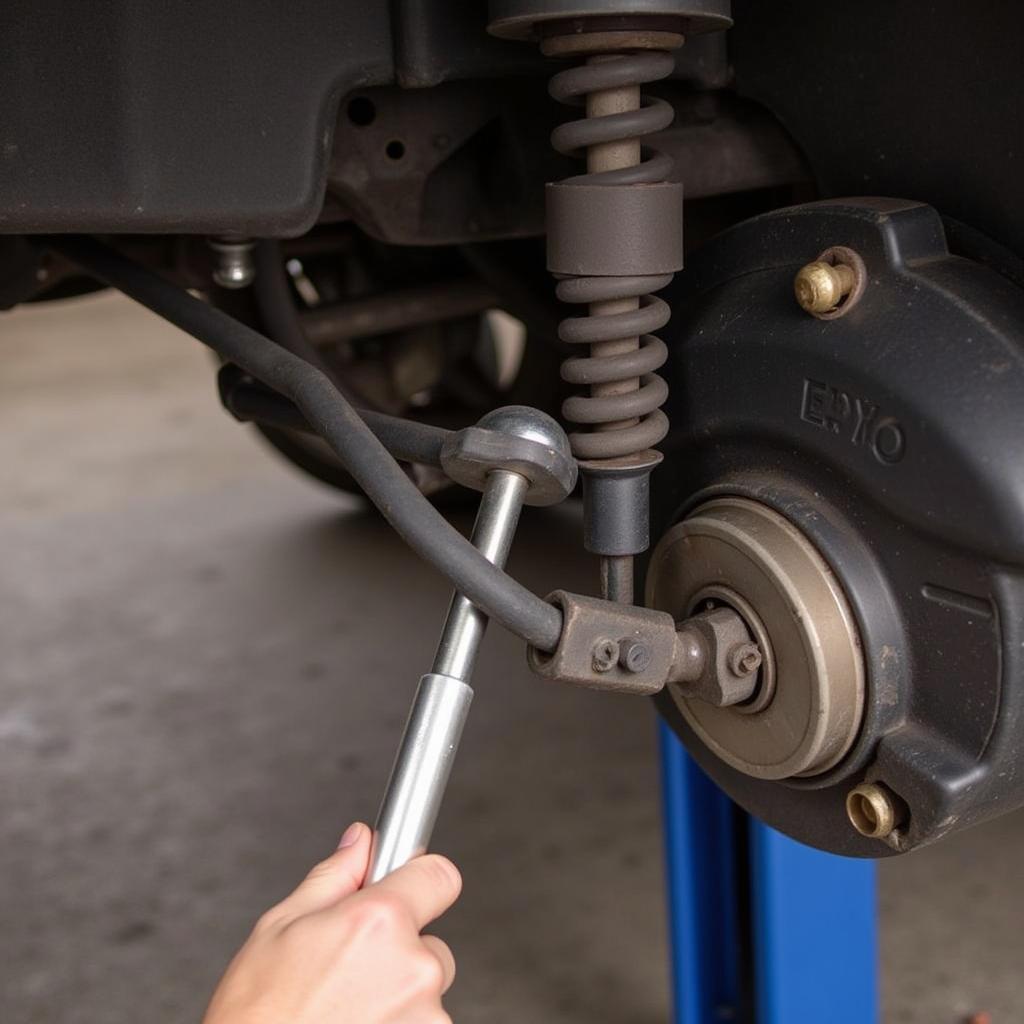 Mechanic Inspecting Ball Joint with Pry Bar