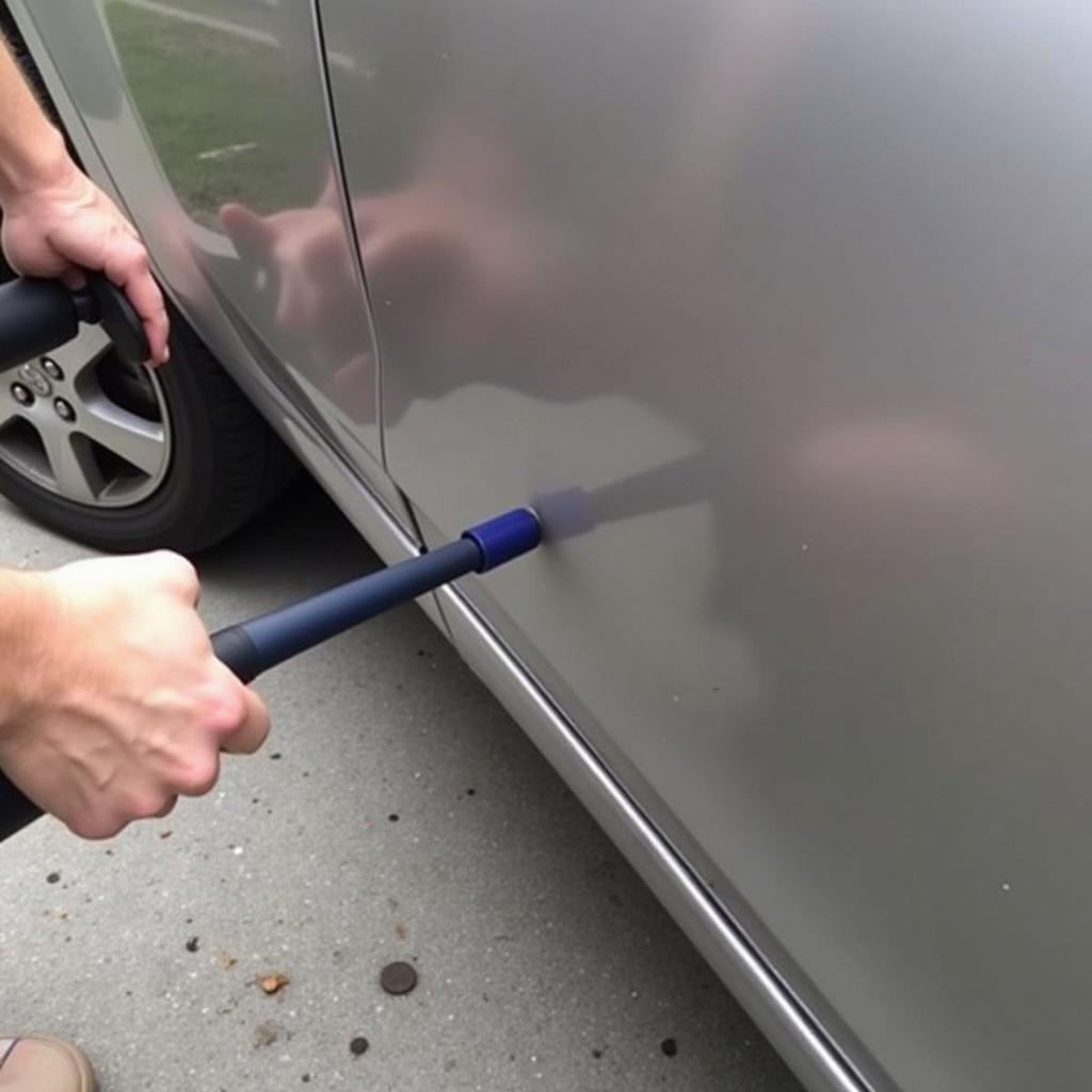 Using a plunger to remove a dent from a car