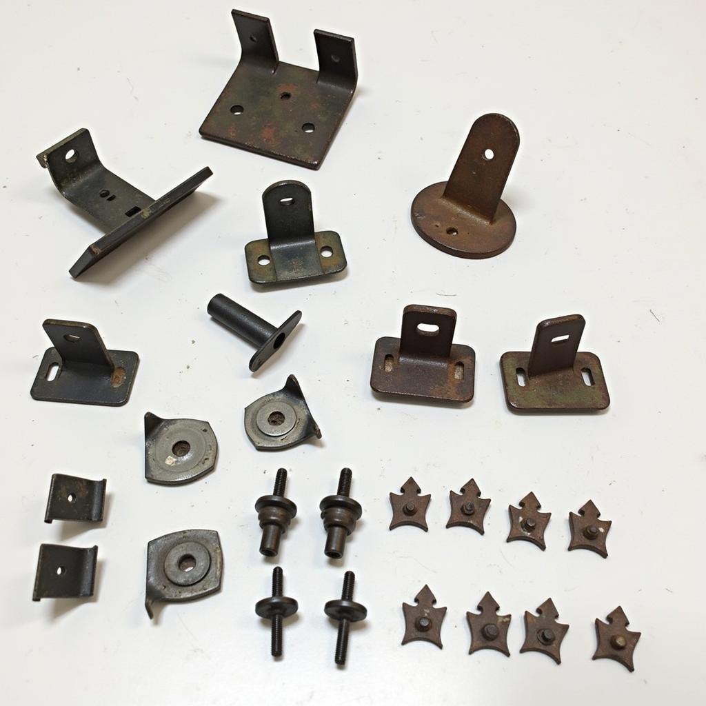 Car bumper clips and brackets in various states of disrepair, including broken and rusted examples.